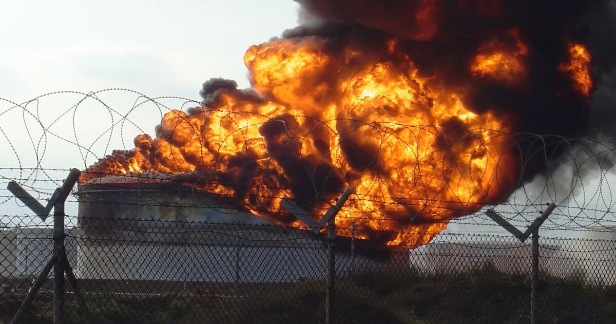 explosion at oil refinery behind fence